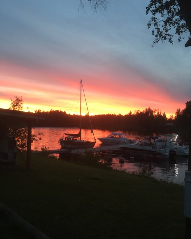 Auringonlasku Kerman rannalla, veneet laiturissa